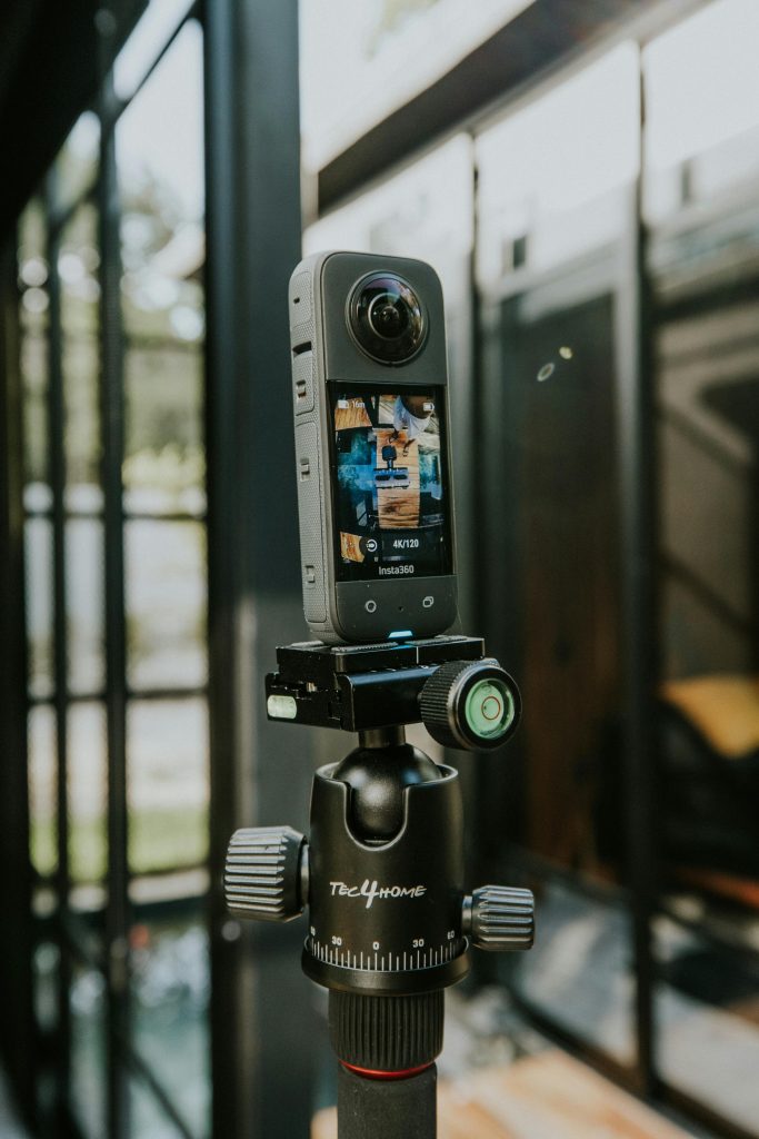 pexels-photo-18868649-18868649 A 360-degree camera mounted on a tripod outdoors in a modern styled location.